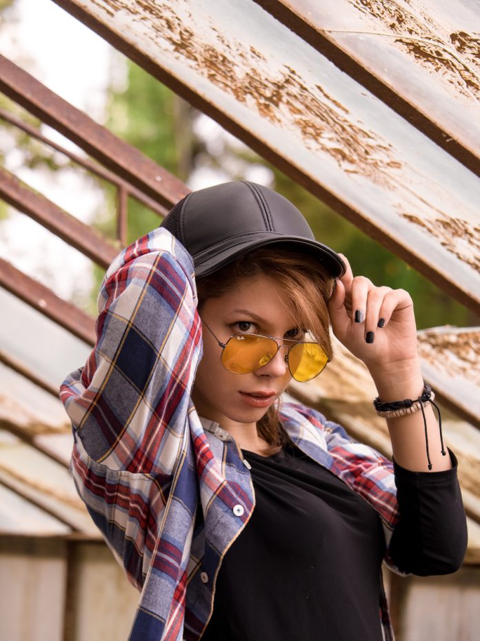 a young woman wearing a hat and sunglasses