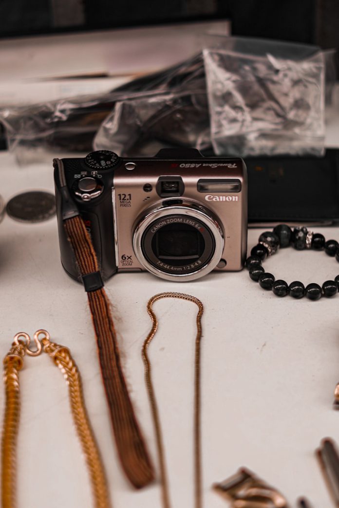 A digital camera surrounded by jewelry and accessories