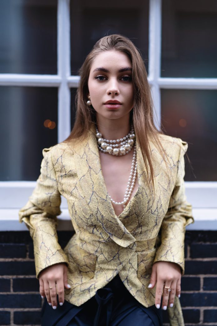 A woman in a yellow jacket and black pants