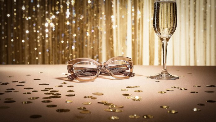 Champagne glass and glasses on a table with confetti.