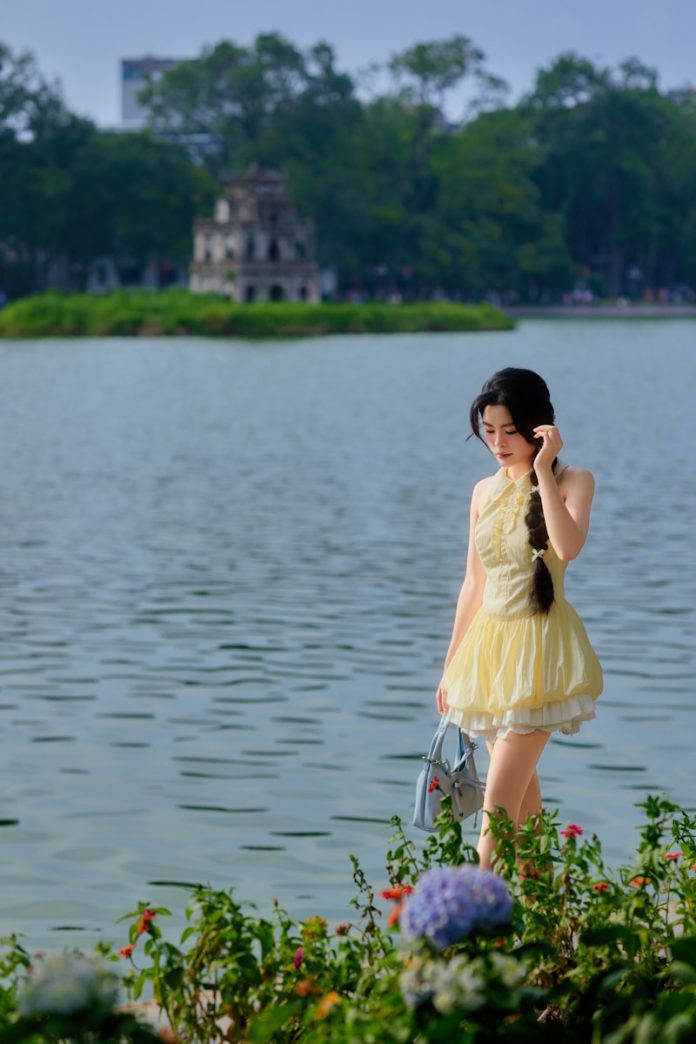 Young woman in yellow dress by a lake