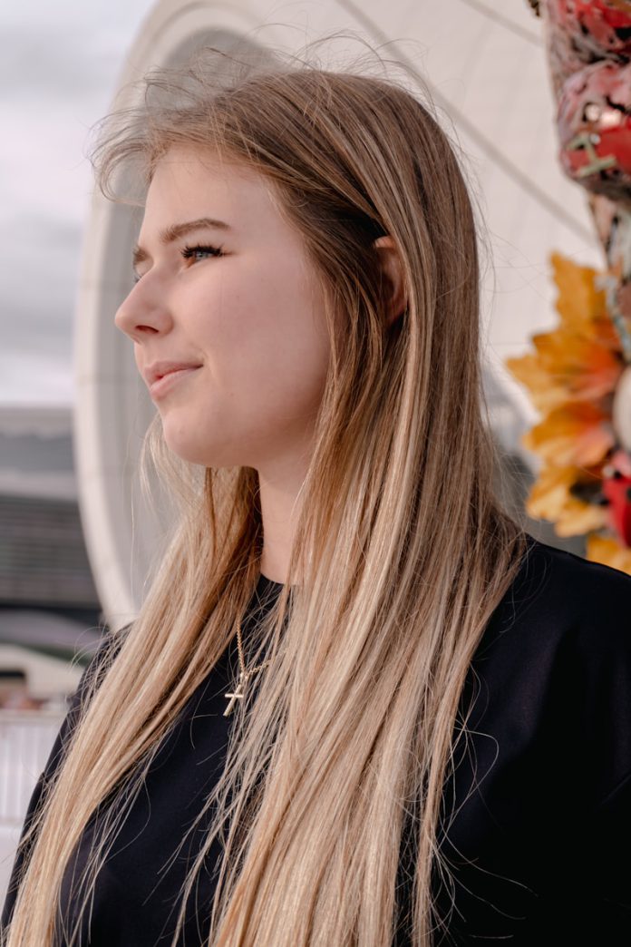 Young woman with long blonde hair looking away